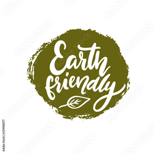 Earth friendly badge, white handwritten text on green grunge stain. Round sign for eco friendly products and sustainable packaging. Handwritten calligraphy vector text