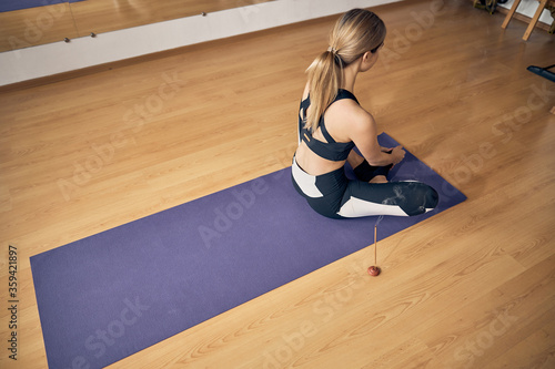 Blond woman sitting on the rubber violet mat