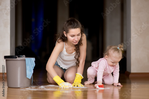 Fényképezés Mom and daughter wash the floor together at home
