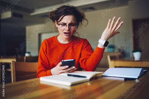 Fototapet Angry attractive female feeling disappointed receiving bill from banking service