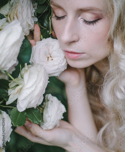 Beautiful young woman with tenser roses in the garten