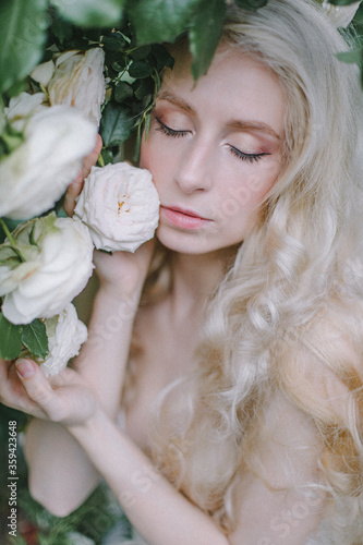 Beautiful young woman with tenser roses in the garten