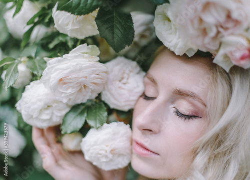 Beautiful young woman with tenser roses in the garten