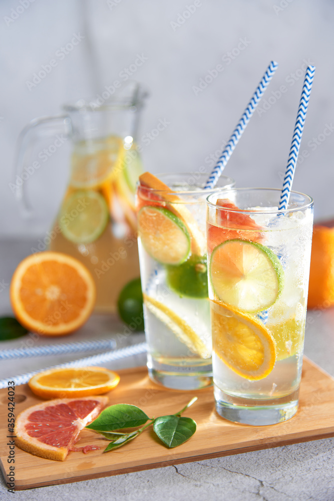 Homemade citrus water with grapefruit, orange, lemon and lime and ice in glass Homemade citrus water with grapefruit, orange, lemon and lime and ice in glass