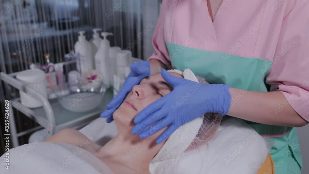 Professional beautician does facial massage to a woman in a beauty salon. Professional beautician does facial massage to a woman in a beauty salon.