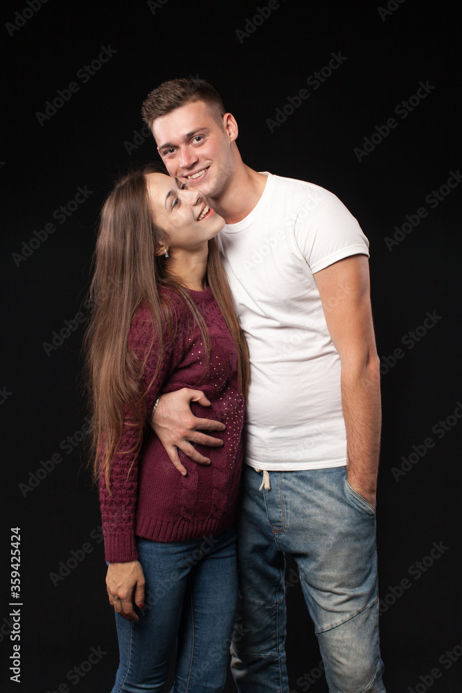 Smiling happy loving couple in studio on black background Smiling happy loving couple in studio on black background