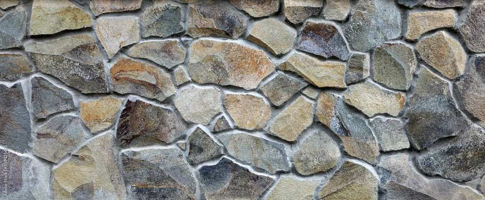 Fototapeta premium Stone wall texture of different forms stones. Wall cladding with granite stones.