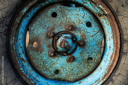 Blue rusty wheel from a tractor close up
