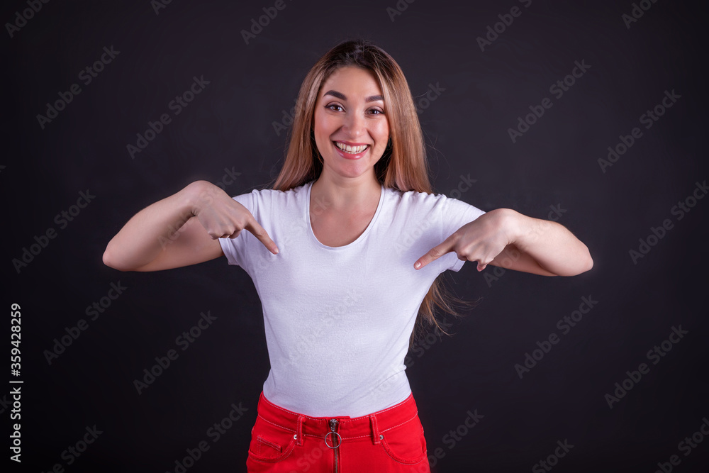 The laughing girl points at her t-shirt. The concept of advertising The laughing girl points at her t-shirt. The concept of advertising