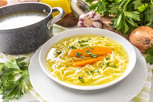 Obraz na płótnie Chicken soup broth in a plate carrot onion celery herbs garlic and fresh vegetab