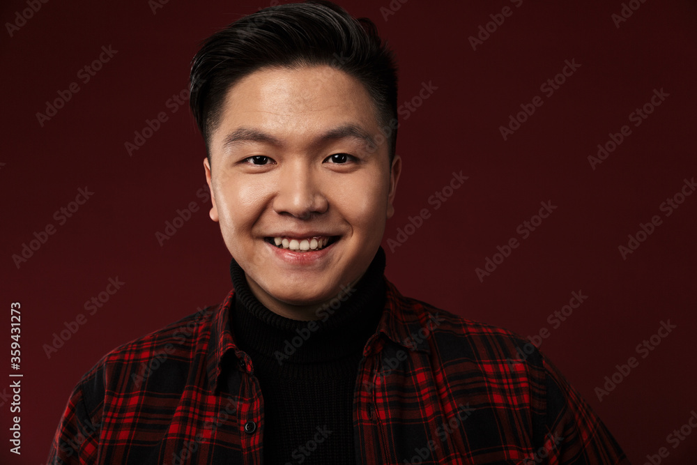 Image of cheerful asian man smiling and looking at camera Image of cheerful asian man smiling and looking at camera