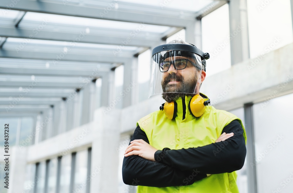 Portrait of worker with protective shield standing at the airport.