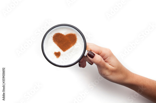 A retro cup with coffee cream. Food art creative concept image, cute drawing with cinnamon powder over milk cream on a white background.