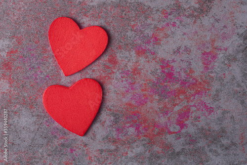 Two red hearts on color stone background with copy space