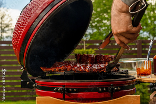 Red Ceramic Barbecue Grill. The man BBQ expert in  Grilling, Smoking, Baking and Roasting process.
