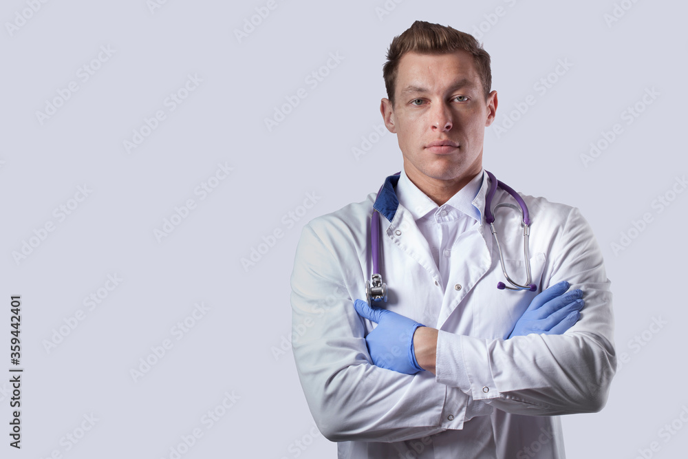 A doctor in a white coat, hands on his chest, calm eyes. Gray background. A doctor in a white coat, hands on his chest, calm eyes. Gray background.