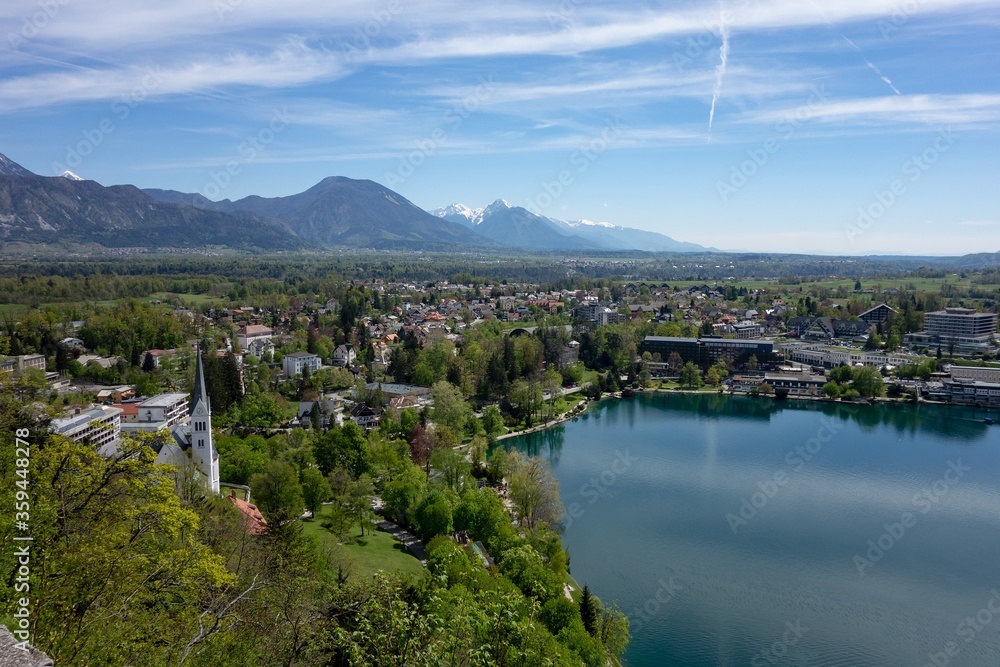 The hotels, commercial buildings without logos and Saint Martin Church in Bled, Slovenia with a Blejsko jezero (Bled lake) in the foreground in nice spring day