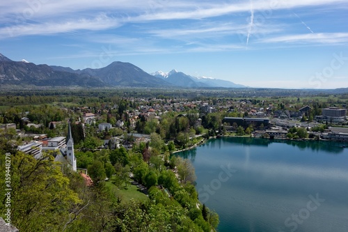 The hotels, commercial buildings without logos and Saint Martin Church in Bled, Slovenia with a Blejsko jezero (Bled lake) in the foreground in nice spring day