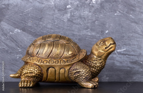 Copper turtle on a dark background. Close up.