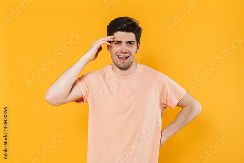 Photo of unhappy bristle man in basic t-shirt crying on camera