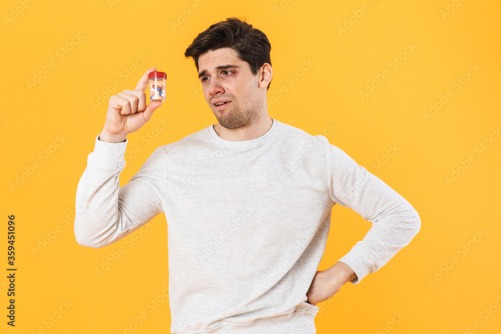 Photo of handsome confused man with allergy posing with medicine Photo of handsome confused man with allergy posing with medicine