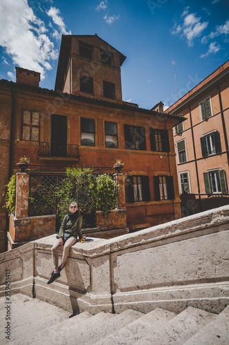 Young attractive blond woman tourist sitting alone on the stairs in Spanish steps in Rome  Italy