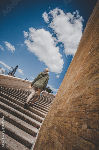 Young attractive blond woman tourist walk on the stairs in Spanish steps in Rome, Italy photo