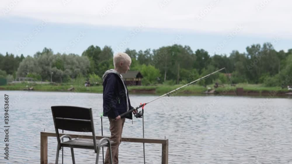A boy catches a fishing rod in a pond. A boy catches a fishing rod in a pond.