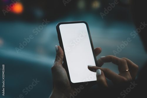 Cropped back view of modern smartphone with blank screen area for your internet content or website.Female hands holding telephone and typing with finger text notification on display