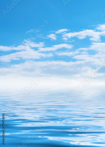 Summer landscape. Blue sea and blurry sky with fluffy clouds. Br