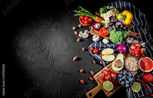 Assortment of fresh fruits and vegetables on dark background. Concept of healthy food. Top view with copy space