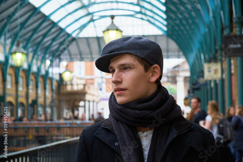 Wallpaper Mural Young casual handsome guy wearing a brown scarf and a trendy gray ivy flat cap, visiting the interior of the former vegetable market of Covent Garden in London. Torontodigital.ca