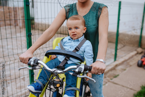 A caucasian mother rides a beautiful child on a bicycle