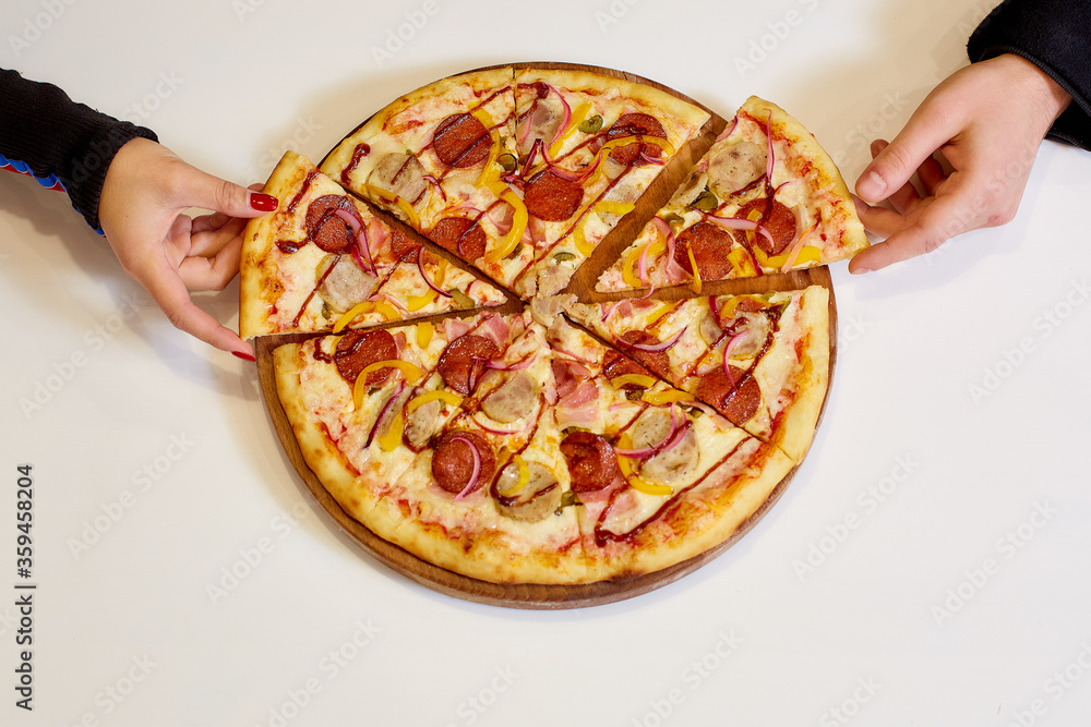 Women's and men's hands take one piece of pizza. White Background