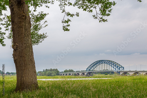 Large blue IJssel bridge crossing the river IJssel in Zwolle, Overijssel in The Netherlands. View from park English work in Zwolle photo