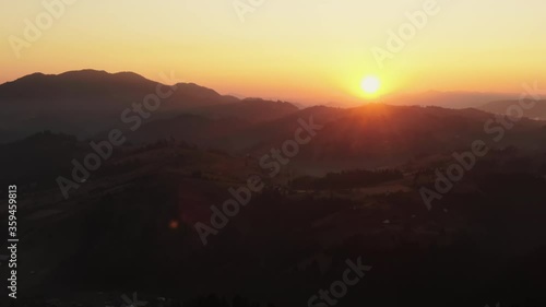 Wallpaper Mural Picturesque aerial view of bright sun setting on cloudless evening sky over mountain range in countryside Torontodigital.ca