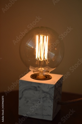 Lampara vintage encendida iluminando mesa de noche photo