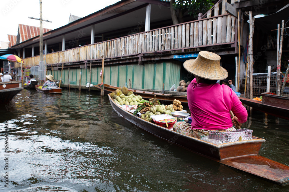 floating market in thailand, a saleswoman with fruits on a long tail boat. Damnoen Saduak, Thailand
