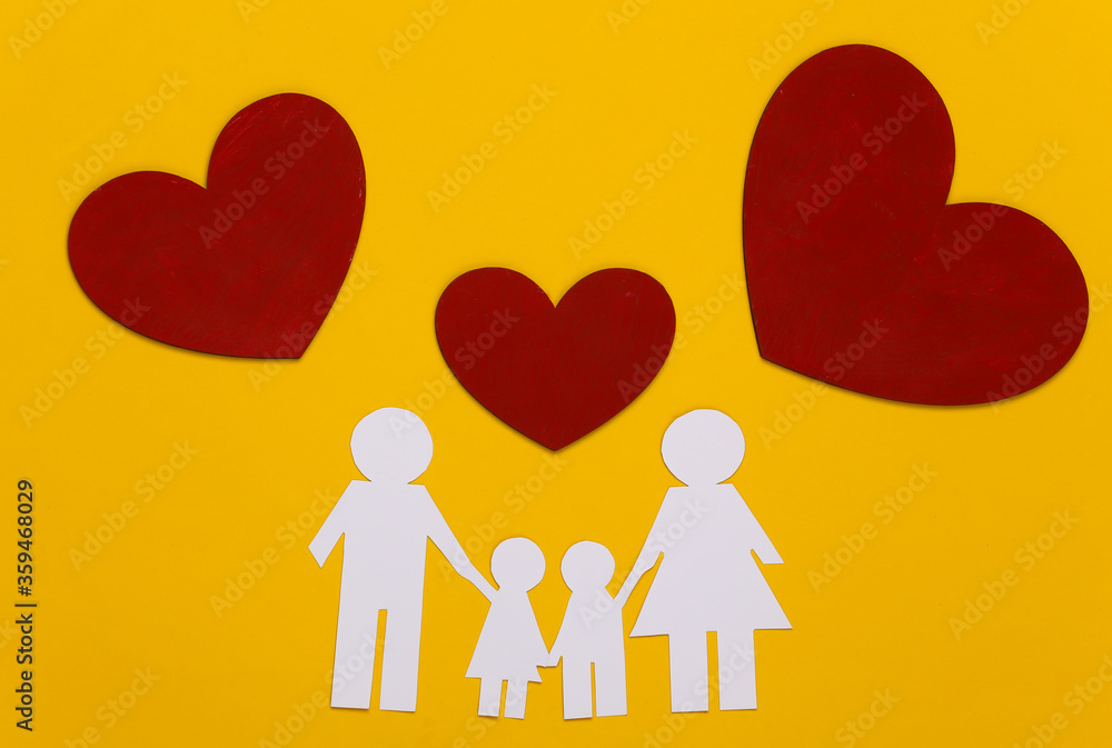 Paper happy family together with red hearts on yellow background Paper happy family together with red hearts on yellow background