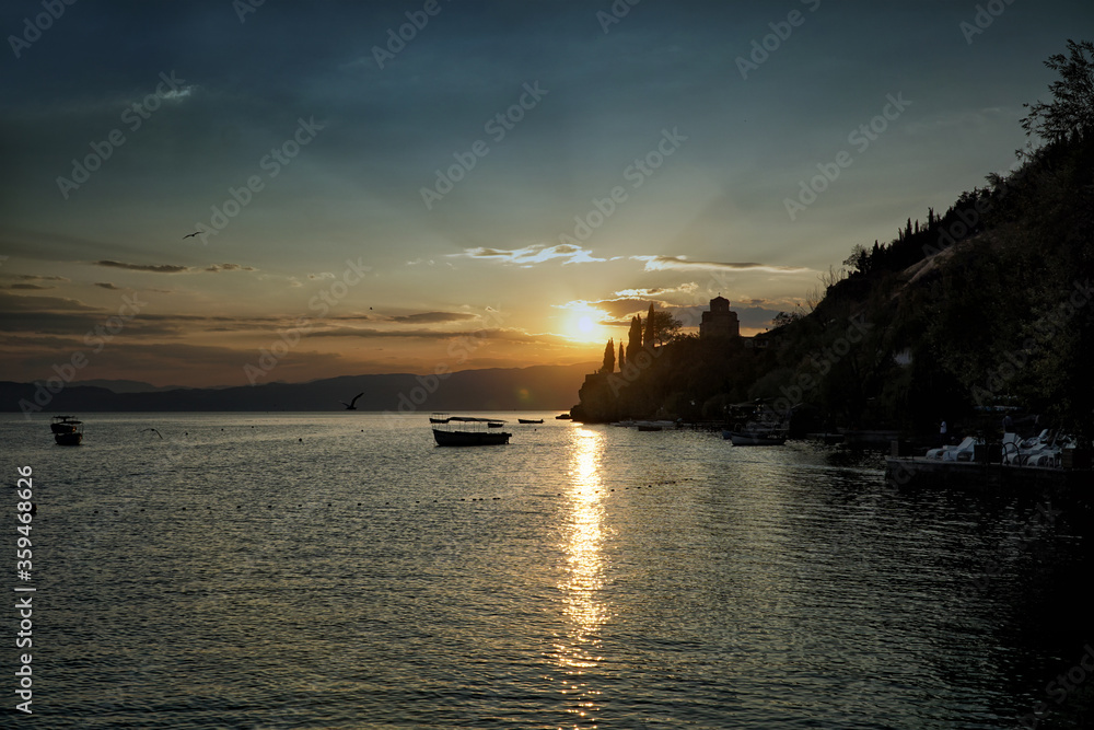 Sunset over Ohrid Lake with silhouette of the Saint John the Theologian, Kaneo church against dramatic sky. North Macedonia, Europe.