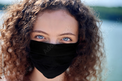 Portrait of a young woman in black medical mask