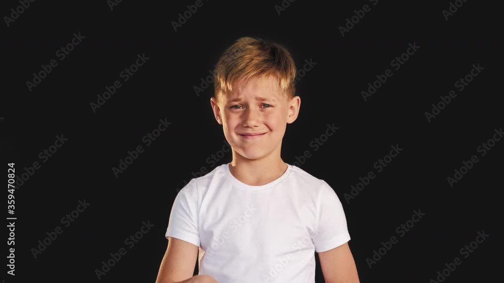 Refusal sign. Stop rejection. Confused boy smiling showing no gesture isolated on black background. Refusal sign. Stop rejection. Confused boy smiling showing no gesture isolated on black background.