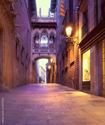 Illuminated medieval street Carrer del Bisbe with Bridge of Sighs in Barri Gothic Quarter in Barcelona  Catalonia  Spain