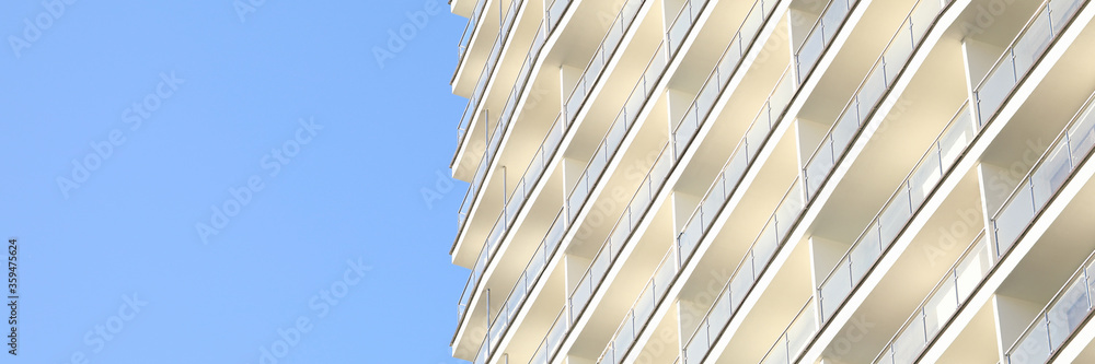 Focus on skyscraper on clear blue sky background. Exterior of house with apartments and many floors. Facade of construction for metropolis. Contemporary architecture Focus on skyscraper on clear blue sky background. Exterior of house with apartments and many floors. Facade of construction for metropolis. Contemporary architecture