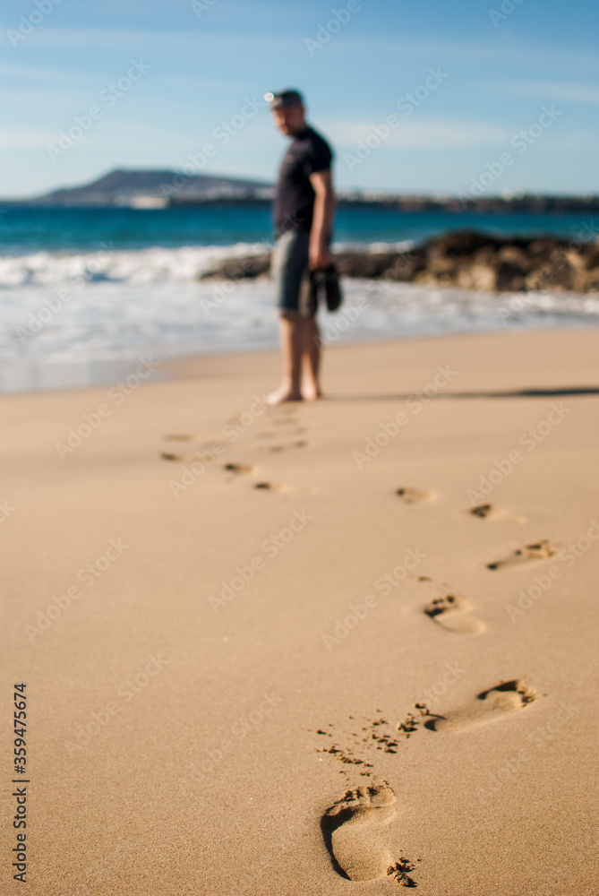 footprints and man walking on the beach of Graciosa island footprints and man walking on the beach of Graciosa island