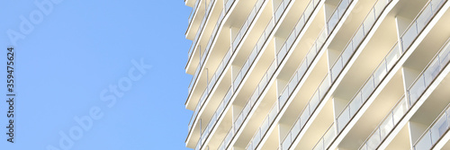 Focus on skyscraper on clear blue sky background. Exterior of house with apartments and many floors. Facade of construction for metropolis. Contemporary architecture