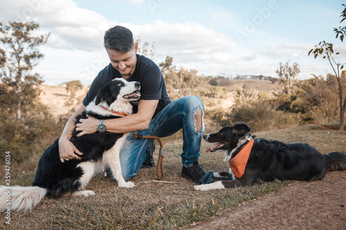 young brazilian man playing with his dogs in the park