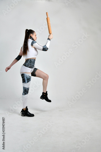 beautiful girl in a robot suit as a housewife with a rolling pin in her hands