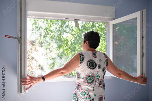 Obraz na plátně Woman opening the window to take a breath