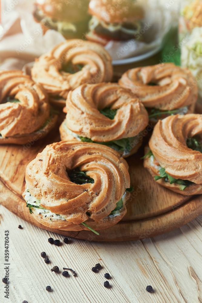 Round bagels with cucumber and herbs on a wooden Board. Close-up. light effects